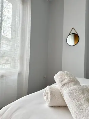 a white bedroom with white towels on a bed at Lemos Sol in Monforte de Lemos