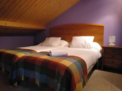 a bedroom with two beds and a wooden headboard at CASA DE CIMADEVILA in Santiso