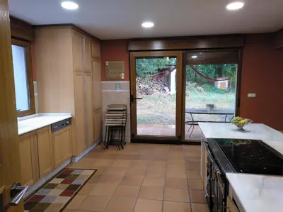 a large kitchen with a view of a yard at CASA DE CIMADEVILA in Santiso
