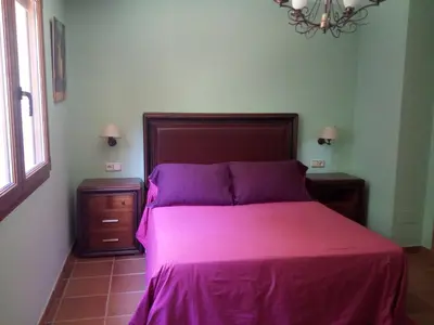 a bedroom with a large bed with purple sheets at CASA DE CIMADEVILA in Santiso