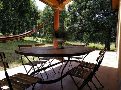 a table and chairs on a patio with a hammock at CASA DE CIMADEVILA in Santiso