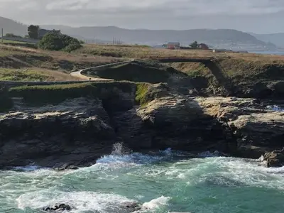 a body of water next to a rocky coastline at El Rinconcito de Foz in Foz