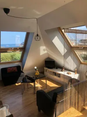 a living room with a couch and two windows at El Rinconcito de Foz in Foz