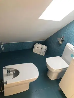 a bathroom with a toilet and a bidet and a sink at El Rinconcito de Foz in Foz