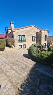 a large brick house with a driveway in front of it at Hotel A Forxa Cafetería Restaurante in Carballeira