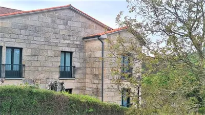 a stone building with windows on the side of it at Hotel A Forxa Cafetería Restaurante in Carballeira
