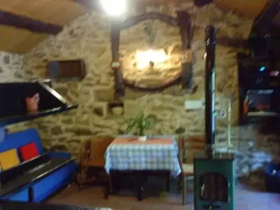 a dining room with a table and a stone wall at Molino de Louzao in Palas de Rei