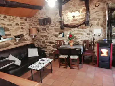 a living room with a couch and a stove at Molino de Louzao in Palas de Rei
