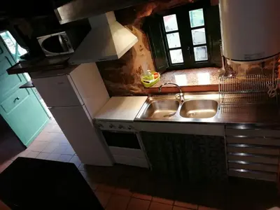 a small kitchen with a sink and a refrigerator at Molino de Louzao in Palas de Rei