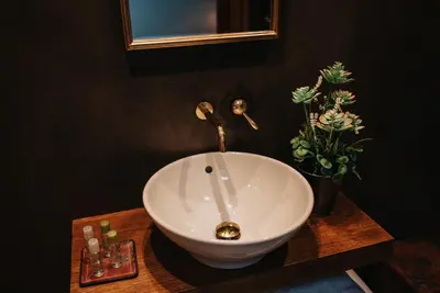 a bathroom with a white bowl sink on a wooden table at 1930 Boutique Hotel in Arzúa