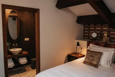 a bedroom with a bed with a sink and a mirror at 1930 Boutique Hotel in Arzúa