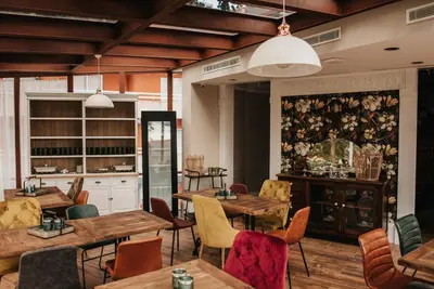 a restaurant with wooden tables and chairs and a kitchen at 1930 Boutique Hotel in Arzúa