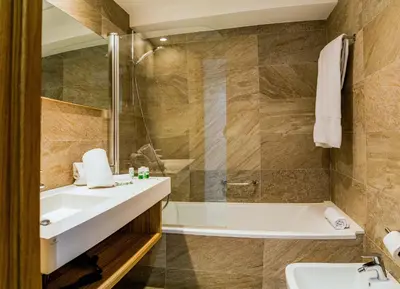 a bathroom with a tub and a sink and a bath tub at Hotel Gelmírez in Santiago de Compostela