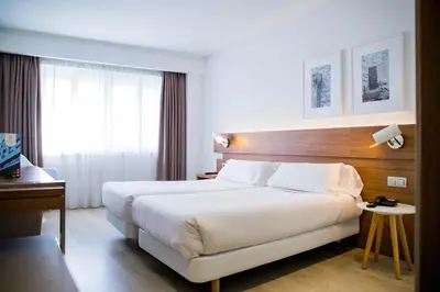 a hotel room with a large bed and a window at Hotel Gelmírez in Santiago de Compostela