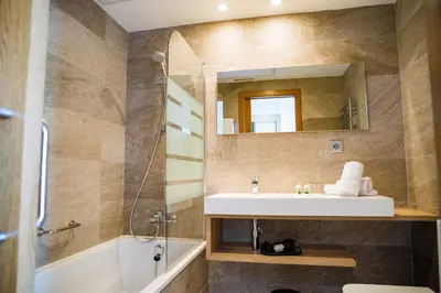 a bathroom with a sink and a shower and a mirror at Hotel Gelmírez in Santiago de Compostela
