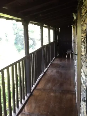 a porch of a cabin with a bench on it at Casa Do Concello in Arnado