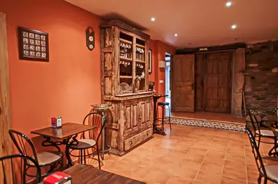 a restaurant with a bar and a table and chairs at Hotel Rural Pajarapinta in Molinaseca