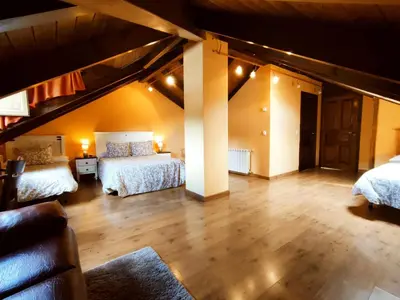 a large room with two beds in a attic at Hotel Rural Pajarapinta in Molinaseca