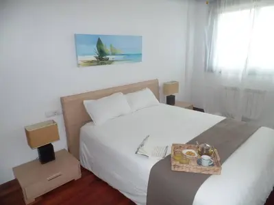 a bedroom with a bed with a tray of food on it at PISO ACOGEDOR EN SADA COZY FLAT IN SADA WiFi in Sada