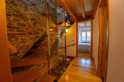 a staircase in a room with a stone wall at Casa Jovellanos de Casas Das Figueiras en Ría Eo-Ribadeo in Castropol