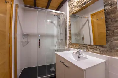 a bathroom with a sink and a shower with a mirror at Casa Jovellanos de Casas Das Figueiras en Ría Eo-Ribadeo in Castropol