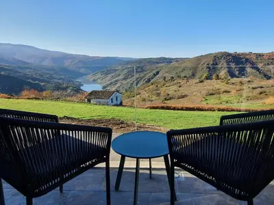 two chairs and a table on a balcony with a view at Miradores do Sil Hotel Apartamento in Cristosende