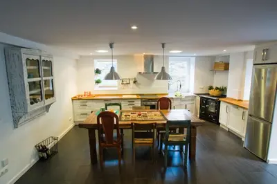 a kitchen with a table and chairs and a refrigerator at La Postoca in Viavélez