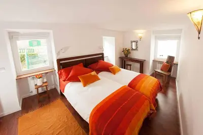 a bedroom with a large bed with orange pillows at La Postoca in Viavélez