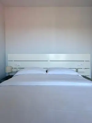 a large white bed in a white bedroom at Lemos Luna in Monforte de Lemos