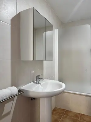 a white bathroom with a sink and a mirror at Lemos Luna in Monforte de Lemos