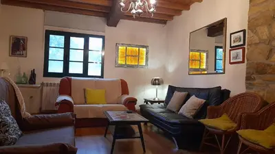 a bedroom with a bed and a chair and windows at Casa de Piñeiro y SPA Opcional con coste extra in Santiago de Compostela