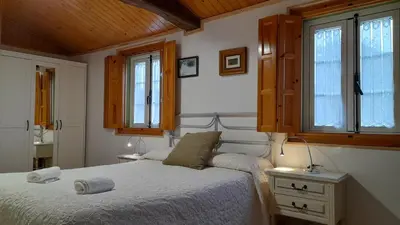 a bedroom with a bed and a window at Casa de Piñeiro y SPA Opcional con coste extra in Santiago de Compostela