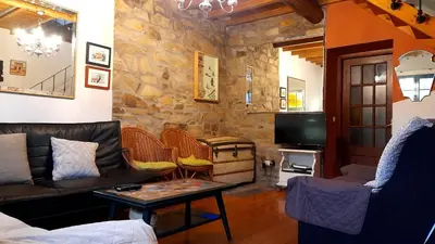 a living room with a couch and a tv at Casa de Piñeiro y SPA Opcional con coste extra in Santiago de Compostela