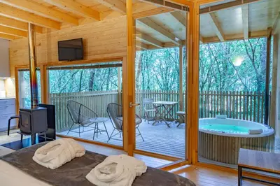 a large room with a hot tub on a deck at Cabañas Enoturismo María Manuela in Pousada
