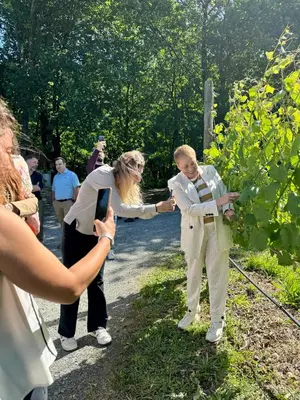 a woman taking a picture of a man in a vineyard at Cabañas Enoturismo María Manuela in Pousada