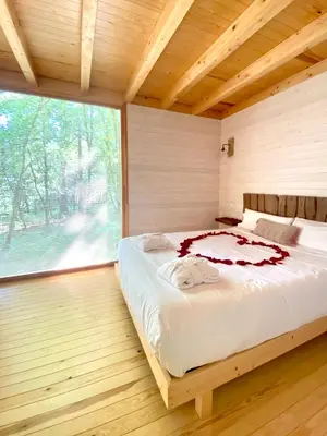 a large bed in a room with a large window at Cabañas Enoturismo María Manuela in Pousada