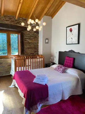 a bedroom with a large bed with pink pillows at Casa Compostela in Bama
