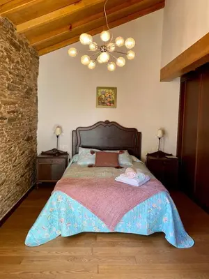a bedroom with a large bed and a chandelier at Casa Compostela in Bama