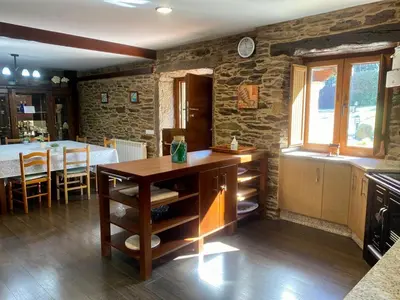 a kitchen with a table and a dining room at Casa Compostela in Bama