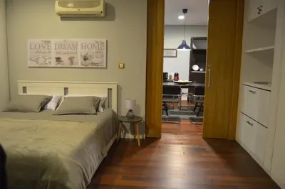 a bedroom with a bed and a hallway with a table at ÁGORA LUX in Ourense
