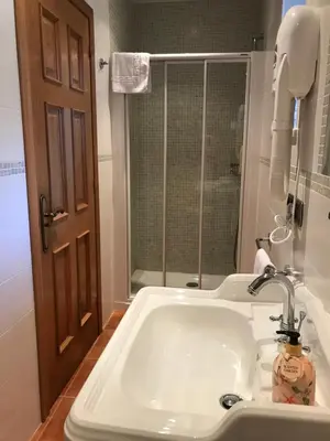 a bathroom with a sink and a shower at Pensión Xacobe in Cabreiros