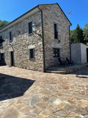 a stone building with a bench in front of it at Pensión Xacobe in Cabreiros