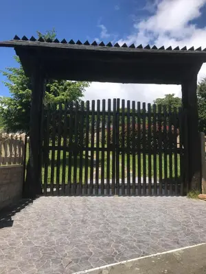 a black gate with a stone patio at Pensión Xacobe in Cabreiros