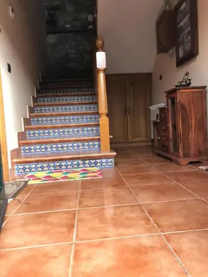 a room with a staircase and a tiled floor at Pensión Xacobe in Cabreiros