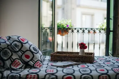 a table with a pillow and a vase on a balcony at Hotel Arco de Mazarelos in Santiago de Compostela