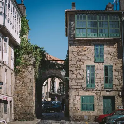 an old stone building with an arch in a street at Hotel Arco de Mazarelos in Santiago de Compostela