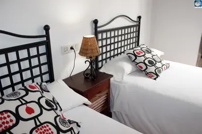 a bedroom with two beds and a lamp on a night stand at Hotel Arco de Mazarelos in Santiago de Compostela