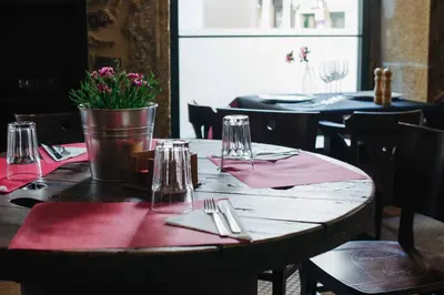a wooden table with pink napkins and glasses on it at Hotel Arco de Mazarelos in Santiago de Compostela