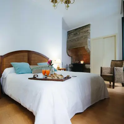 a large white bed with a tray of food on it at Hotel Arco de Mazarelos in Santiago de Compostela