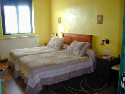 a bedroom with a bed and a window at Hostería Casa Flor in Murias de Rechivaldo